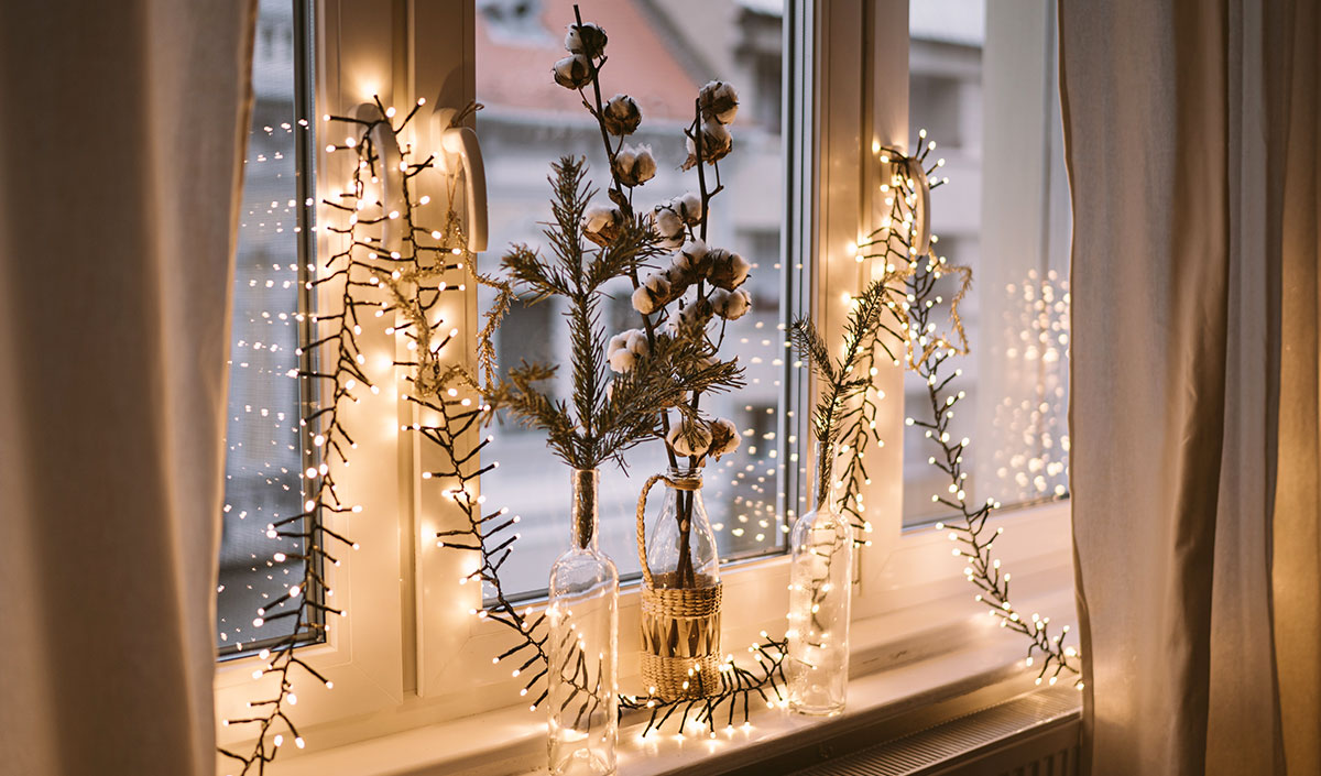 Décoration de Noël : guirlande lumineuse près d'une fenêtre 