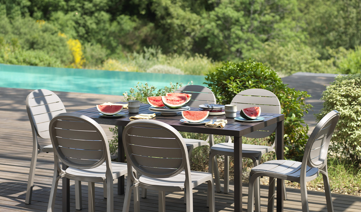 Tables et chaises de jardin au bord de la piscine 