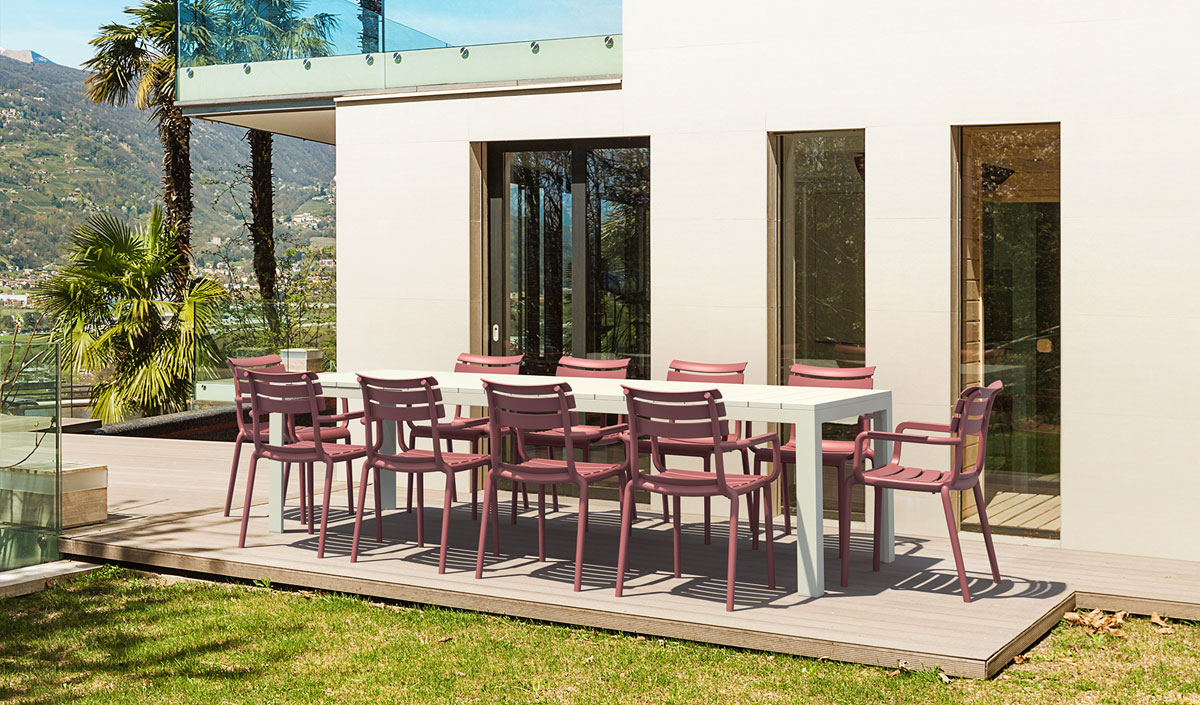Table de jardin blanche avec chaises avec accoudoirs rose.