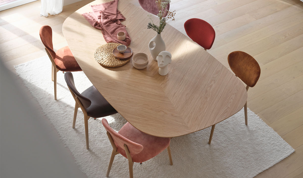 Chaises dépareillées cocooning dans une salle à manger avec des nuances de couleurs