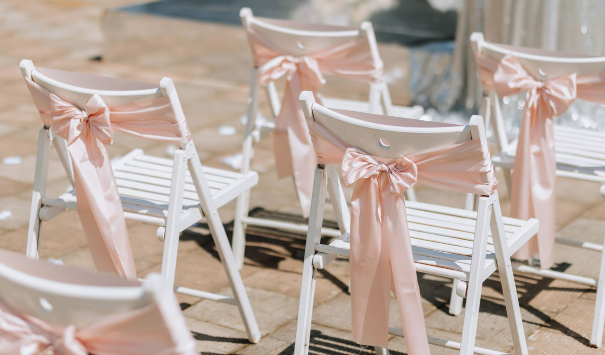 Faire un nœud avec un ruban sur les chaises de mariage